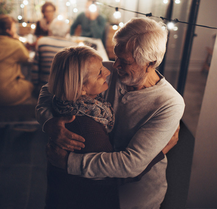 A couple at a party, hugging and looking into each others eyes